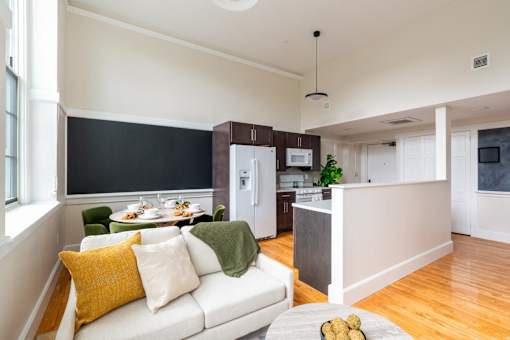 a living room and kitchen with a white couch and a table at Beverly Village for Living & the Arts Apartments, Beverly, 01915