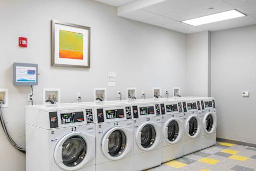 A row of washing machines numbered 13, 14, and 15 at Edmands House, Framingham, 01701