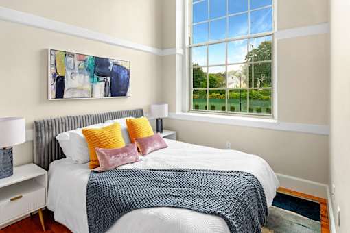 a bedroom with a bed and a large window at Beverly Village for Living & the Arts Apartments, Beverly, 01915