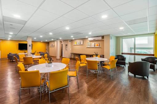 A room with a white table surrounded by yellow chairs. at Ship's Watch Apartments, Fall River, MA, 02720
