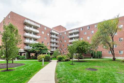 A large red brick building with a walkway in front of it at Edmands House, Framingham, 01701