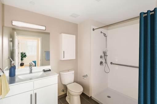 a bathroom with a shower toilet and sink and a mirror at Beverly Village for Living & the Arts Apartments, Beverly, 01915
