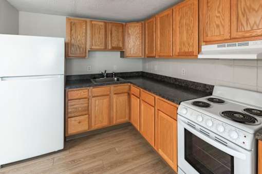 A kitchen with wooden cabinets and a white refrigerator.