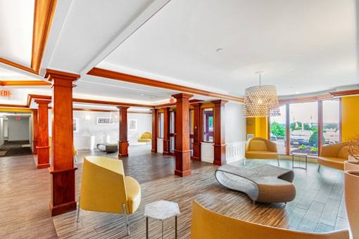 A large room with yellow chairs and a white table. at Ship's Watch Apartments, Fall River, MA, 02720