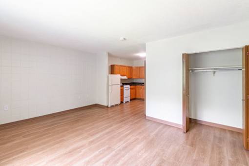 A room with a white wall and a wooden floor.