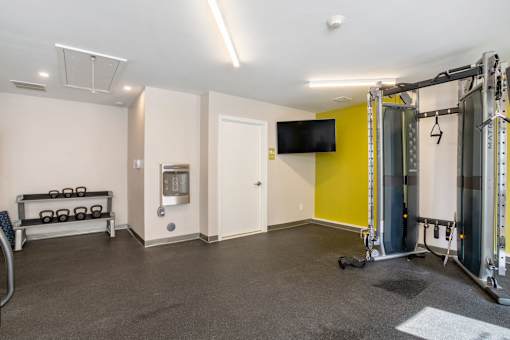Community Fitness Center with weights and a tv on the wall at Station Pointe Apartments, Mansfield, MA, 02048