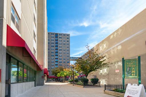 A sunny day at the entrance of a building with a sign that says "Twin Village".