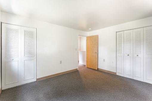 Bedroom with carpet and closet doors at Blue Ridge Estates Apartments, Virginia