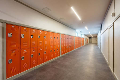 a row of orange lockers in a hallway in a building at Beverly Village for Living & the Arts Apartments, Beverly, 01915