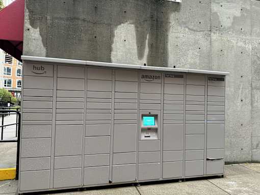 A grey Amazon vending machine with a green screen on the front.