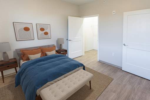 A bedroom with a bed, nightstand, and two framed pictures on the wall  at 35 Broadway Apartments, Menands, New York