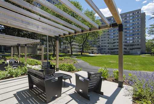 Outdoor seating area with pergola and gardens at Baystate Place Apartments, Massachusetts