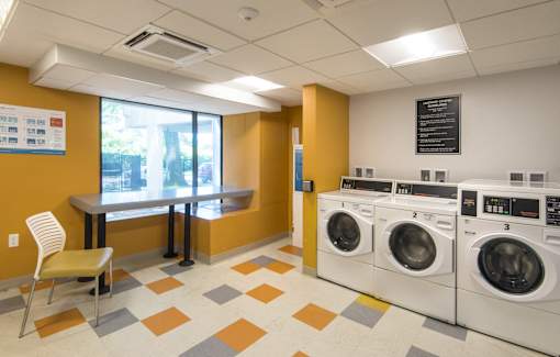 Community laundry center with washers and seating at Baystate Place Apartments, Massachusetts