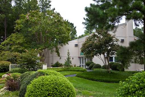 Manicured grounds with mature trees and shrubs at Blue Ridge Estates Apartments, Richmond, VA 23225