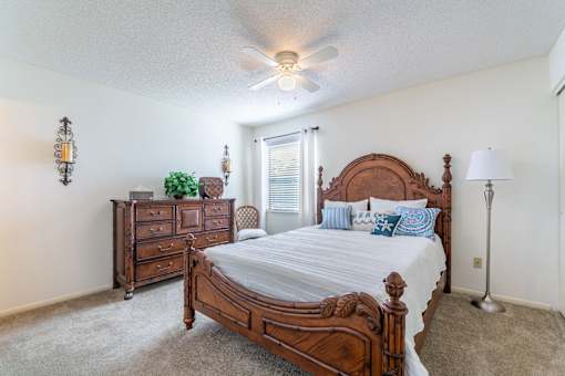 A bedroom with a large bed and a dresser Fishermans Landing Apartments in Ormond Beach, FL.