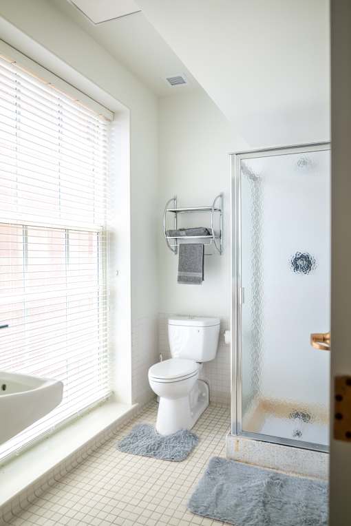 a white bathroom with a shower toilet and sink  at 140 Clarendon, Boston, MA