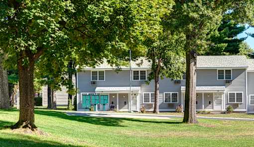 A white building with a green lawn in front at Colonial Estates Apartments, Springfield, Massachusetts