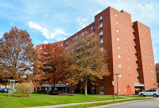 A large red brick building with a car parked in front.