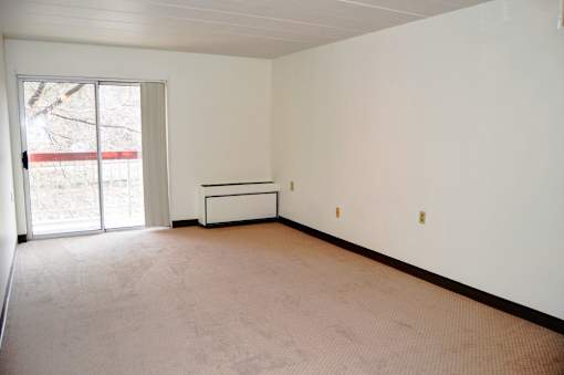 Empty room with a bench and sliding glass doors.