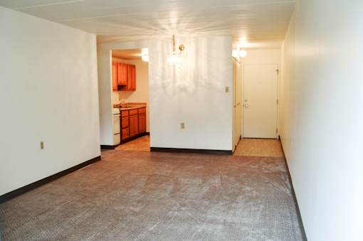 A room with a carpeted floor and a door on the right side.