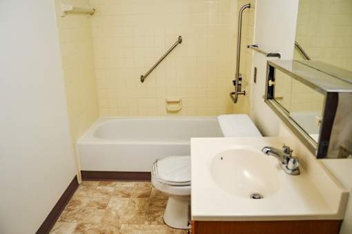 A white toilet sits next to a sink in a bathroom.