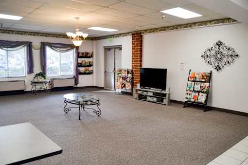 A living room with a television, a coffee table, and a fireplace.