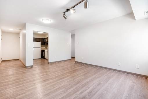 A large empty room with wooden floors and white walls.