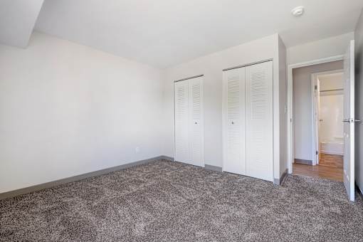 A room with white walls and a grey carpet.