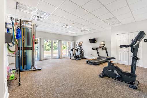 A spacious room with exercise equipment and a television.