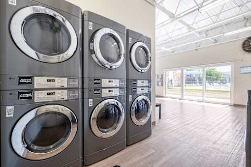 A row of front-loading washing machines in a laundromat.