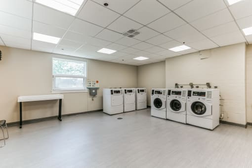 an empty laundry room with washers and dryers