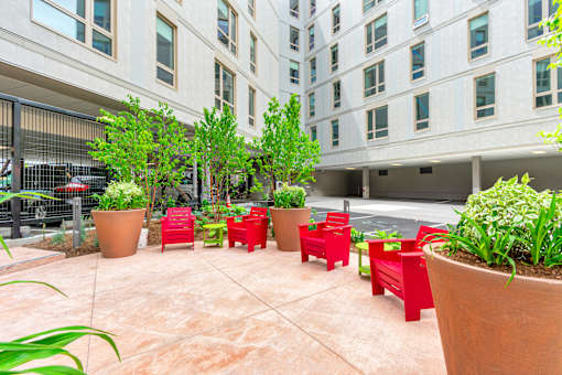 A courtyard with red chairs and plants at Pok Oi Residences, Boston, MA, Massachusetts, 2111