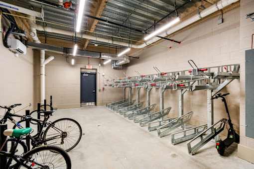 A bike rack with bikes and a scooter in a garage