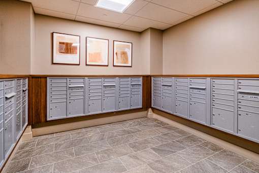 A row of grey lockers are lined up against a wall with two framed pictures hanging above them at Pok Oi Residences, Boston, MA, Massachusetts, 2111