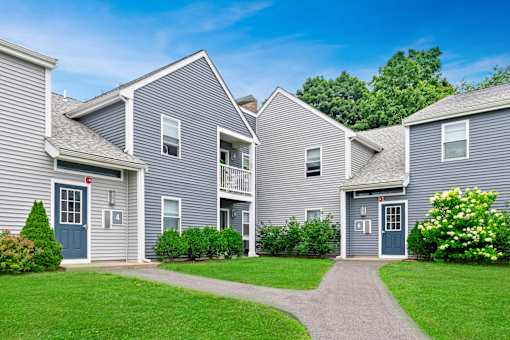 a row of houses with blue siding and green grass at Blue Hills Village, Canton, Massachusetts