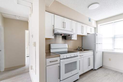 A kitchen with white appliances and cabinets.