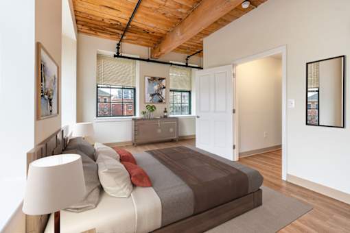 A bedroom with a bed and a lamp at The Cordovan at Haverhill Station, Haverhill, MA