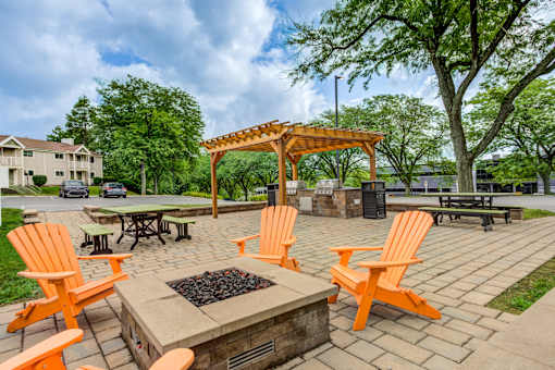 A fire pit surrounded by orange chairs in a park at Williamsburg Estates, Harrisburg, PA, 17112