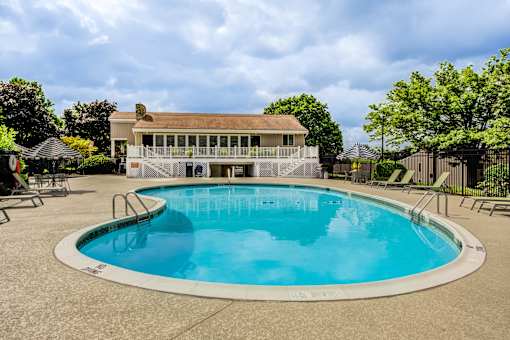 A large outdoor pool with a deck and a house in the background at Williamsburg Estates, Harrisburg, PA, 17112