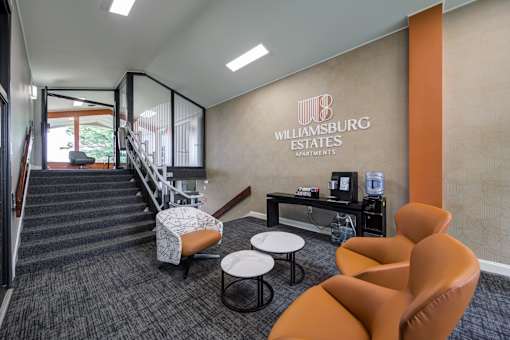 A modern office space with orange chairs and a staircase leading to the upper floor at Williamsburg Estates, Harrisburg, PA, 17112
