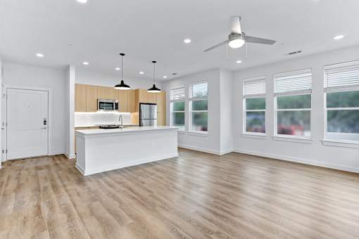 A spacious kitchen with a white island and wooden flooring.