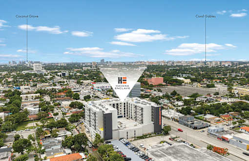 A large building with a sign that says "ENCLAVE" is in the middle of a city.