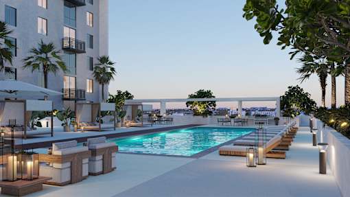 A modern poolside lounge area with a view of the city.