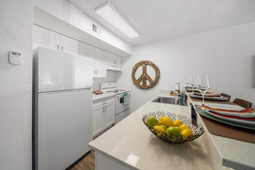 A kitchen with a bowl of fruit on the counter.