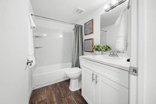 A white bathroom with a toilet, sink, and bathtub.