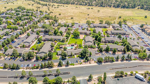 A bird's eye view of a residential area with houses and parked cars.