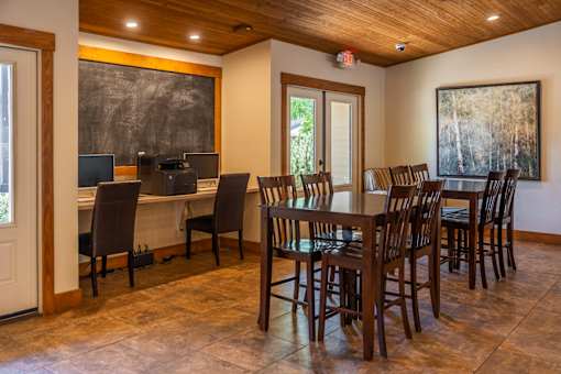 A dining room with a wooden table and chairs.