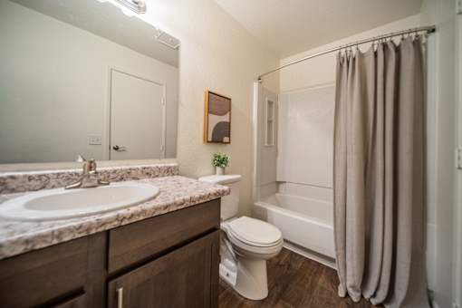 A bathroom with a sink, toilet, and bathtub.