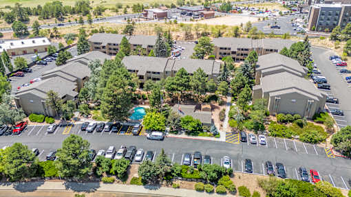 A parking lot with cars and a building in the background.