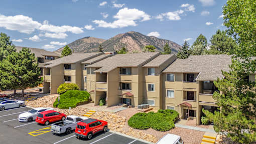 A parking lot with cars and a building in the background.
